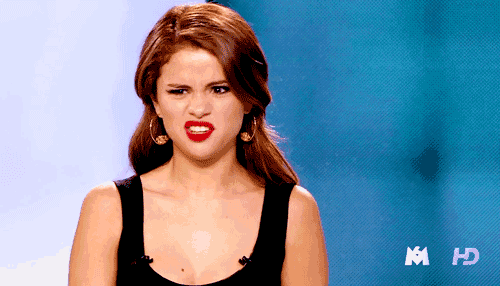 a woman in a black tank top is making a funny face