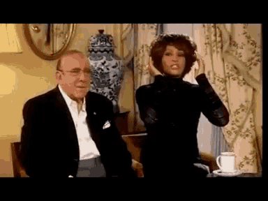 a man and a woman are sitting at a table with a cup of coffee