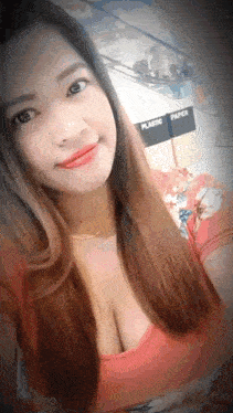a woman in a red top is taking a selfie .