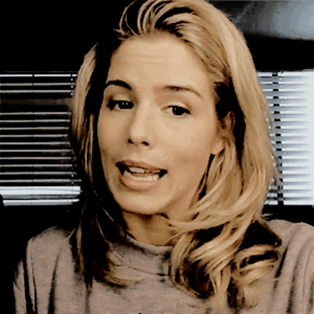 a close up of a woman 's face with a gray shirt on