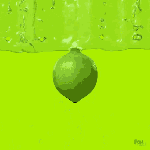 a green ball is splashing into a green liquid