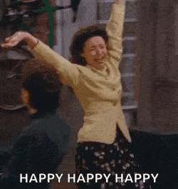 a woman is dancing in a hallway with her arms in the air and the words `` happy happy happy '' behind her .