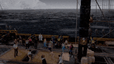 a group of people are standing on a deck of a ship in the ocean