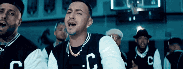 a man in a black and white jacket with the letter c on it