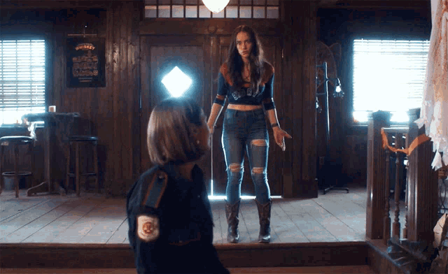 two women are standing in a room with a sign that says whiskey on it