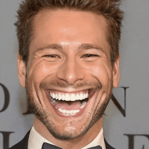 a close up of a man 's face with a big smile