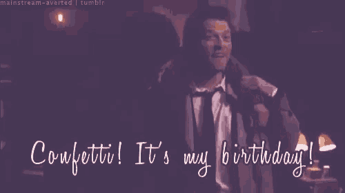 a man in a suit and tie is dancing in a dark room and says `` confetti ! it 's my birthday ! ''