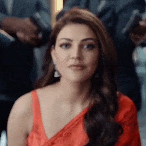 a close up of a woman wearing a red saree and earrings .