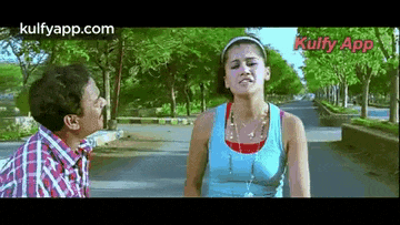 a man and a woman are standing next to each other on a road .
