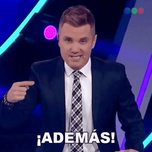 a man in a suit and tie is pointing at the camera and saying ademas