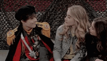 a boy dressed as a military officer is talking to two girls