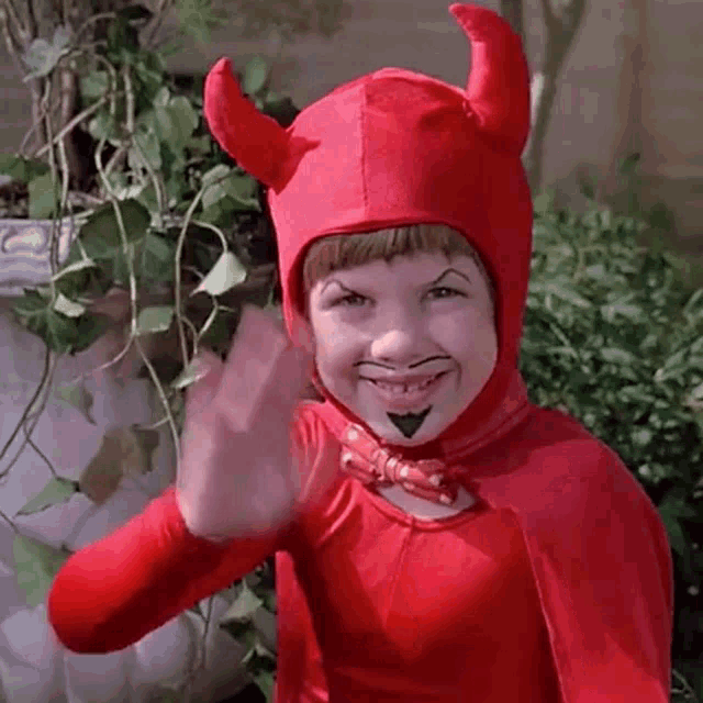 Junior, personagem principal do filme O Pestinha, vestido de diabo e acenando, enquanto sorri