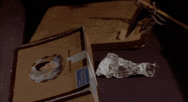 a box of cigars sits on a table next to a piece of crumpled paper
