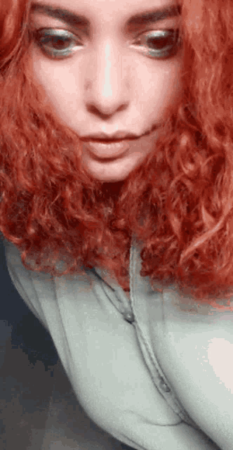 a close up of a woman with red curly hair