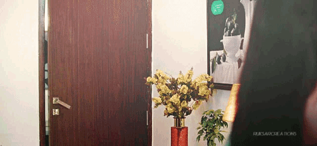 a picture of a vase of flowers hanging on a wall with the word rusarcreations on the bottom