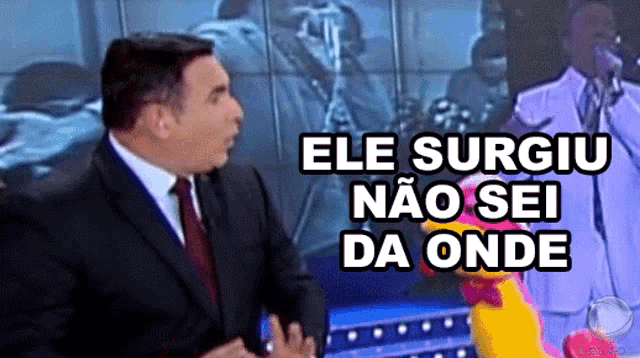 a man in a suit and tie stands next to a stuffed chicken with the words ele surgiu nao sei da onde below him