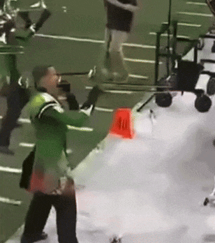 a man in a green jacket is standing in front of a red cone that says 40
