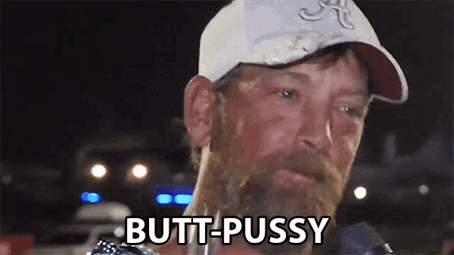 a man with a beard is wearing a white hat and says butt-pussy