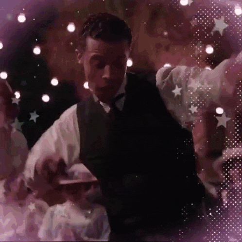 a man in a suit is dancing in a dark room
