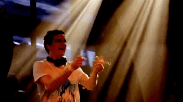 a man in a white shirt is dancing in front of a crowd