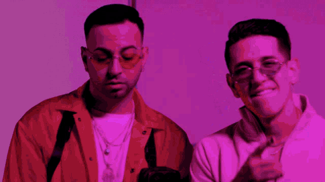 two men standing next to each other with one wearing a white ellesse sweatshirt