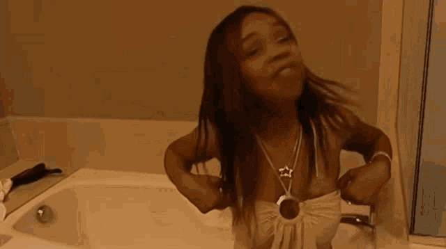 a woman in a white top is standing in a bathtub with her arms outstretched
