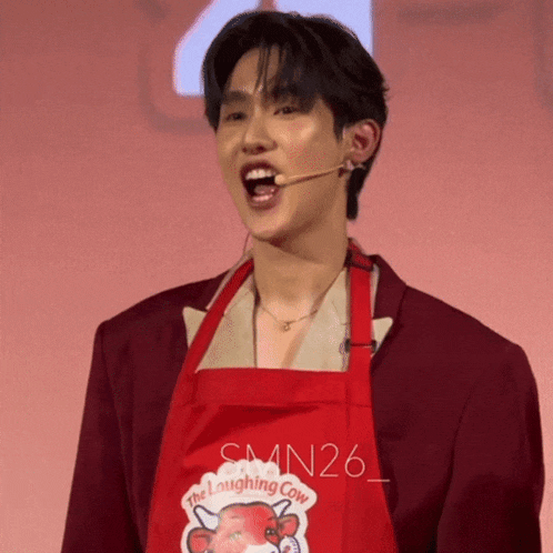 a man is wearing a red apron that says the laughing cow