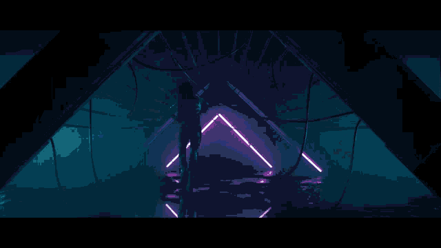 a silhouette of a woman standing in a tunnel with blue lights behind her