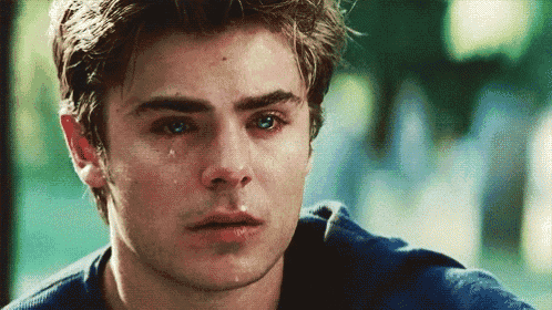 a close up of a man 's face with a tear coming out of his eye .