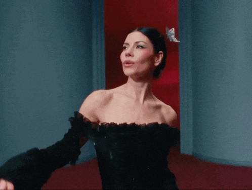 a woman in a black dress has a butterfly on her head
