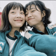 two girls are posing for a picture and one has the number 10 on her shirt