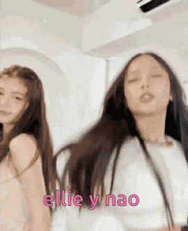 a couple of girls are standing next to each other in a room .