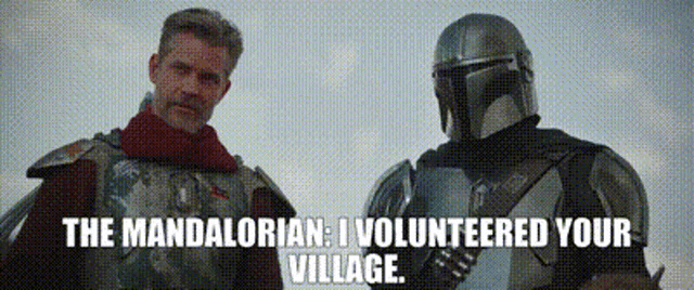 two men in armor are standing next to each other and talking .