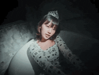 a woman with a tiara on her head is sitting in a bathtub