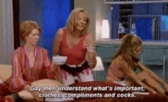three women are sitting on a couch and one of them says gay men understand what 's important : clothes compliments and cocks