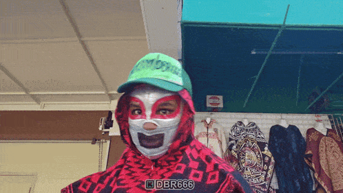 a person wearing a mask and a green hat with dbr666 on the bottom right