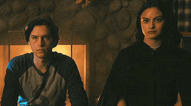 a man and a woman are standing next to each other in a room .