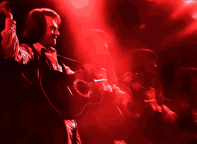 a man playing a guitar with the letter c on the neck