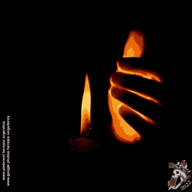 a hand is holding a lit candle with the year 2022 on the bottom right