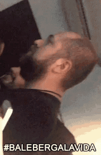 a man with a beard is drinking from a bottle and says #balebergalavida .