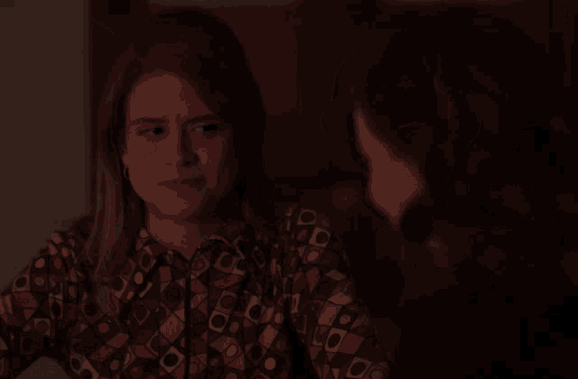 a woman with her eyes closed is wearing a shirt with a pattern of squares