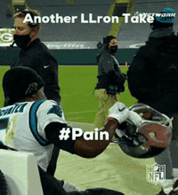 a football player holding a helmet on a field with the words another llron take #pain