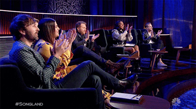 a group of people sitting in chairs applauding a show called songland on nbc