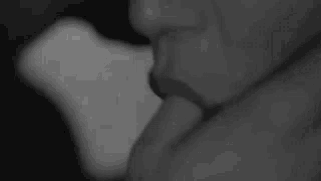 a black and white photo of a person holding another person 's hand in a black and white photo .