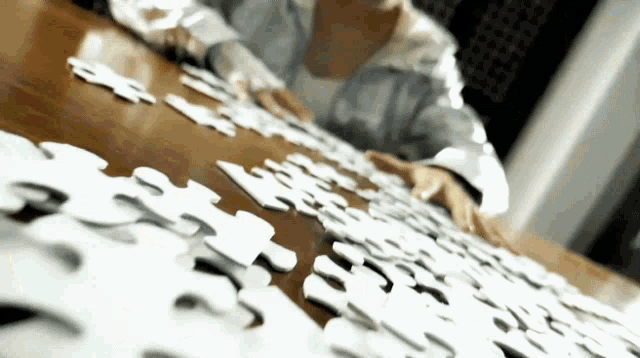 a person is putting puzzle pieces on a table and one of the pieces has the number 3 on it
