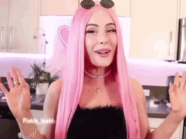 a woman with pink hair is wearing sunglasses and a choker necklace