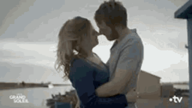 a man and a woman are kissing and hugging each other .