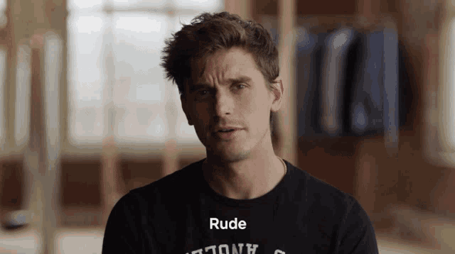 a man in a black shirt with the word rude on it