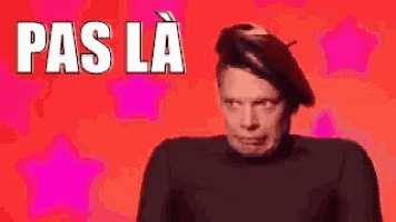 a man wearing a black beret is making a funny face while standing in front of a red background .