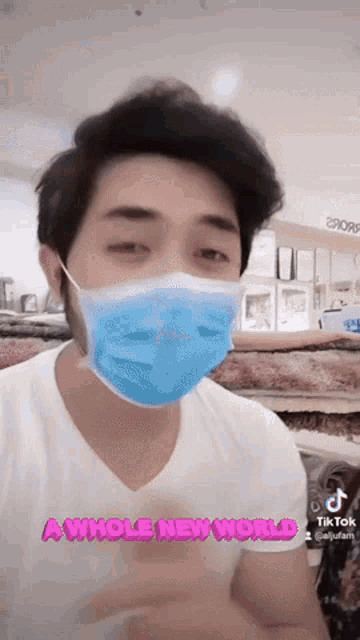 a man wearing a mask and a shirt that says a whole new world .